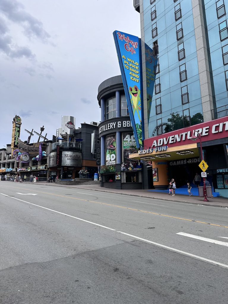 An empty road lined with buildings including the Rainforest Cafe and Niagara Brewing.