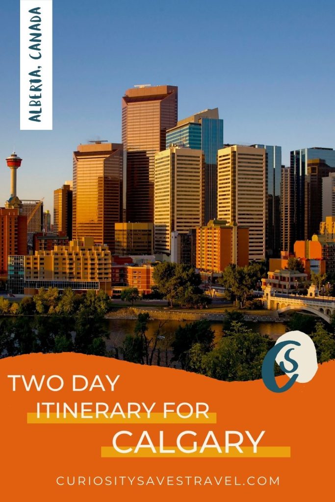 A photo of tall buildings next to a river at golden hour, with a text box at the top left that says "Alberta, Canada" and another bright orange text box at the bottom that says "Two Day Itinerary For Calgary."