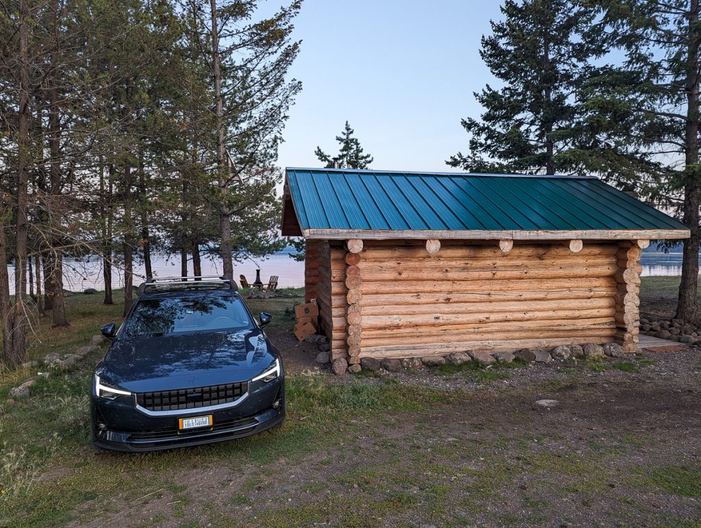 a car near a cabin in the woods