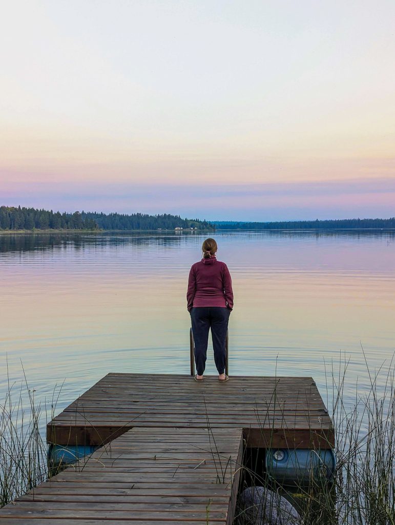 Sooz stands at a lake