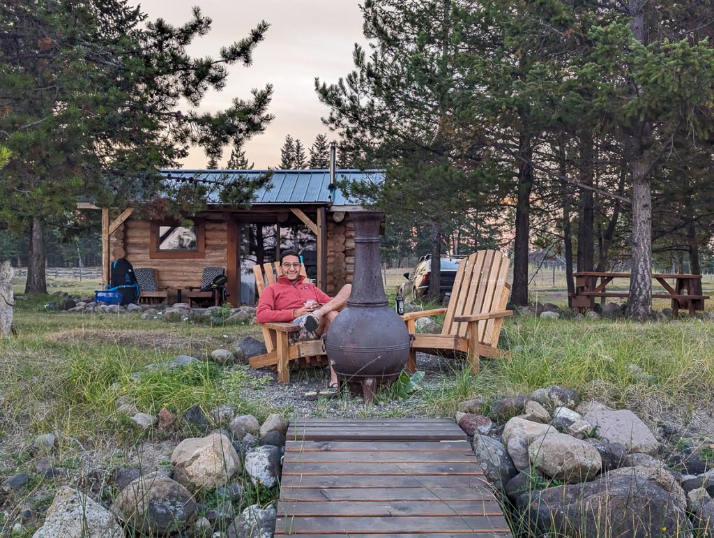 a man sits in front of a cabin