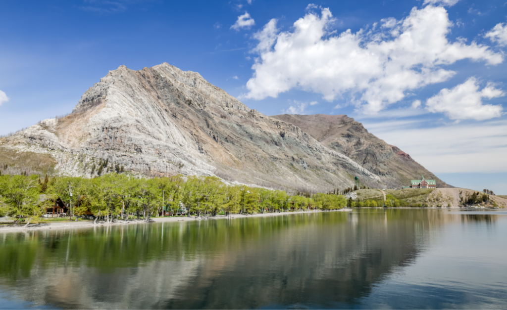 A view of a lake with a heritage hotel in the distance at Waterton Lakes