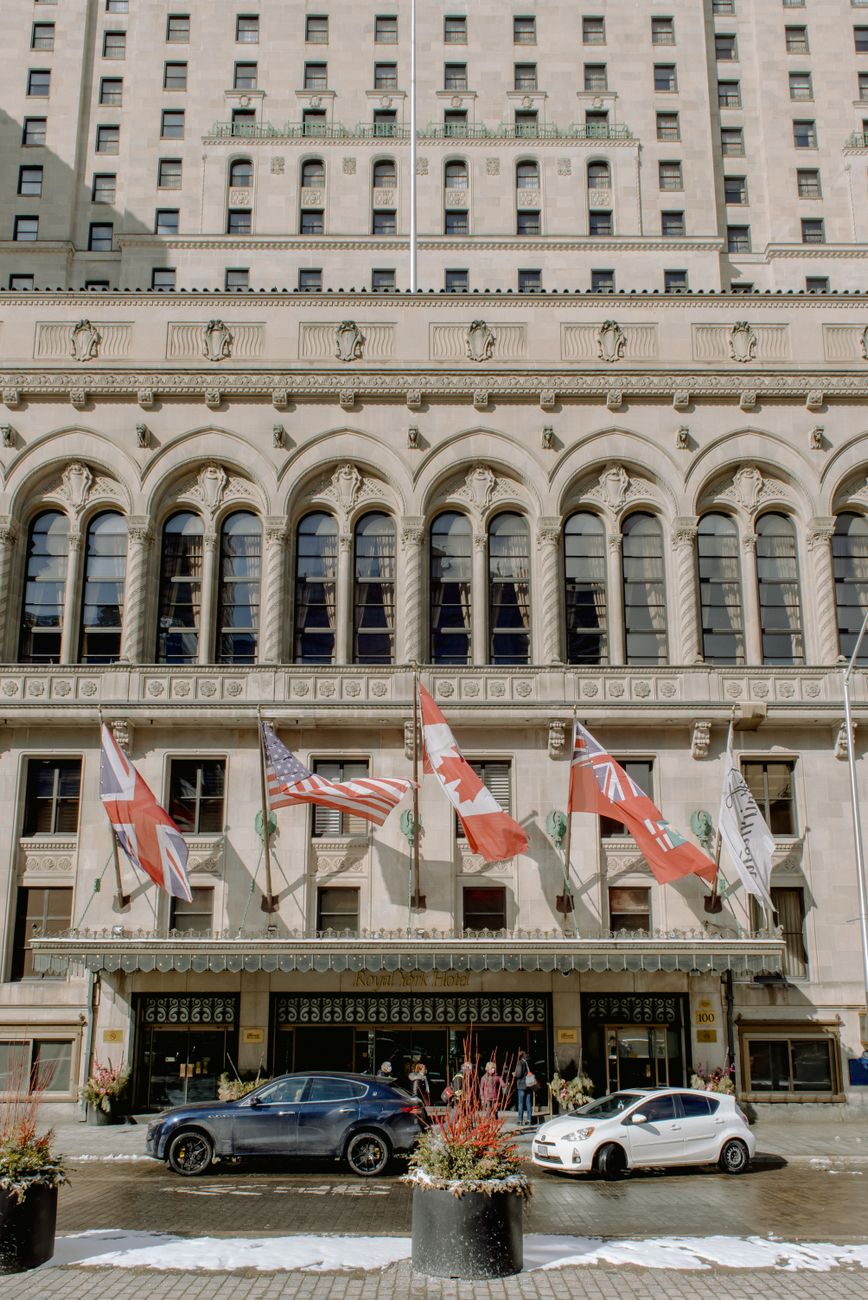cars in front of a building with flags
