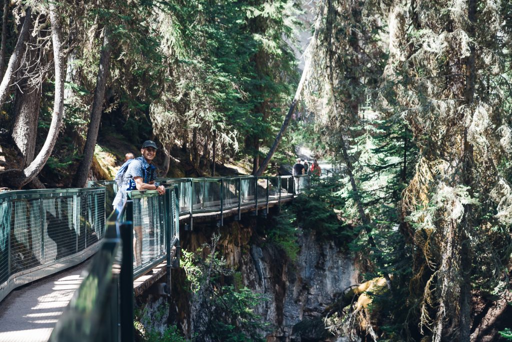 A man on a boardwalk in a Johnstone Canyon