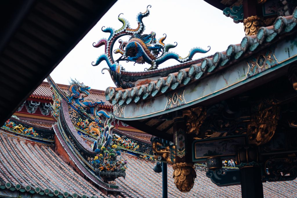 A close up shot of roof details on a temple in Taipei with colorful dragons.