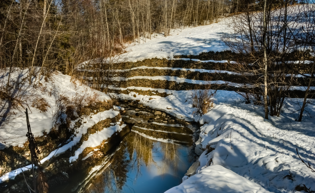A small creek with snow on the banks.