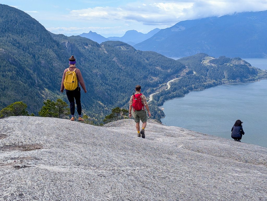 two people hiking stawamus chief in Squamish with views of water and mountains