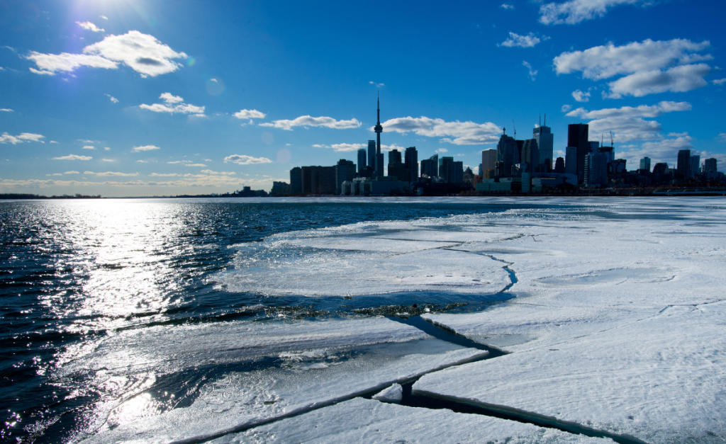 The city skyline from Toronto as seen from the semi-frozen water on a clear sunny day.