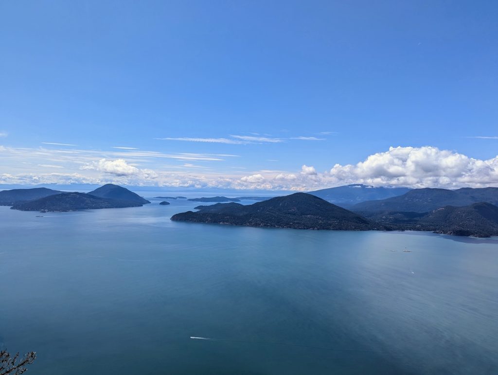 View from the top of Tunnel Bluffs hike in Vancouver. Blue waters, islands, and blue skies.