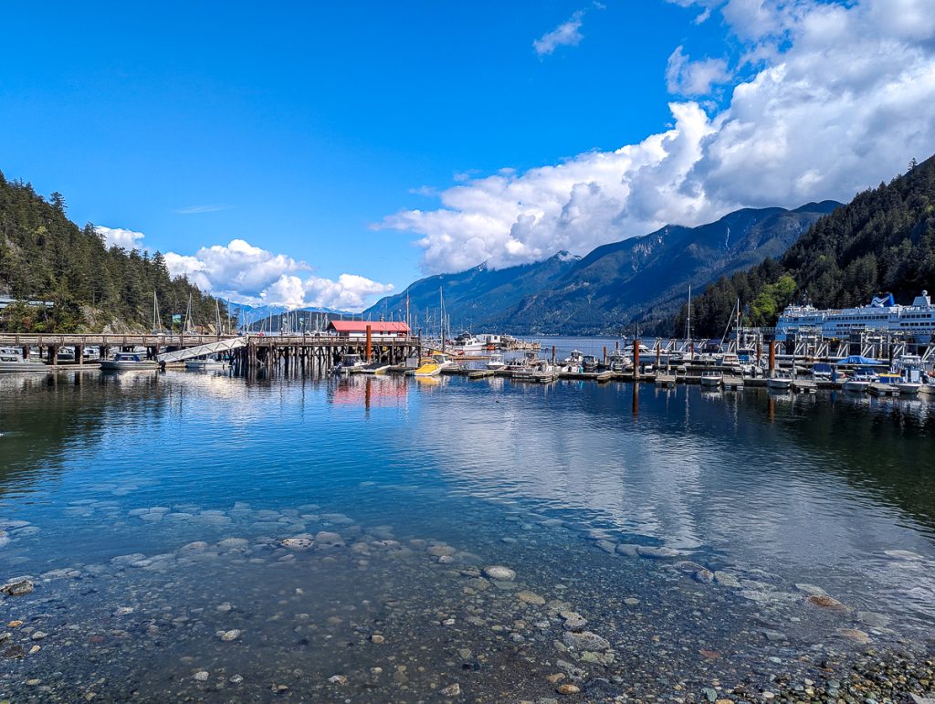 a marina with blue water and mountains in Horseshoe Bay West Vancouver