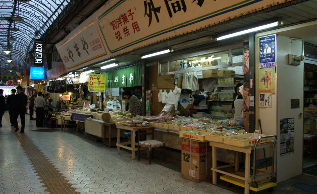 An undercover market with stalls with Japanese writing on the signs.